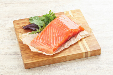 Raw salmon fillet over board