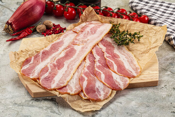 Sliced pork bacon over board