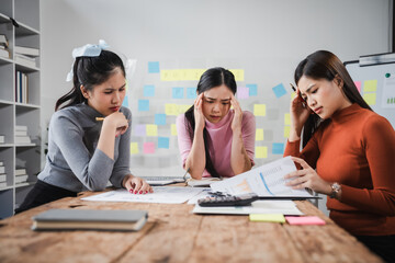 Asian people, frustrated businesswoman sits at desk, grappling with challenges of her startup, acknowledging failure, and seeking ways to learn and grow. team meeting. blamed