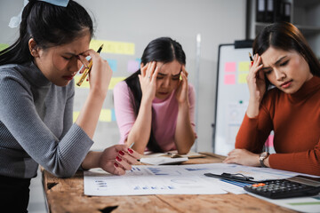 Asian people, frustrated businesswoman sits at desk, grappling with challenges of her startup, acknowledging failure, and seeking ways to learn and grow. team meeting. blamed