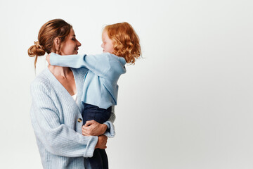 Mother and daughter embracing in front of a white backdrop loving family moment captured in studio setting