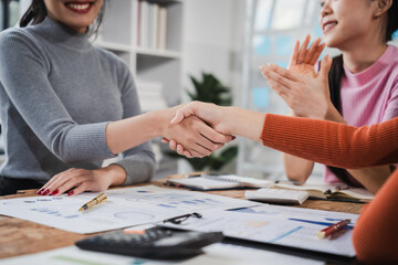Shaking hands, Asian people, motivated businesswoman at her desk, brainstorming creative ideas to...