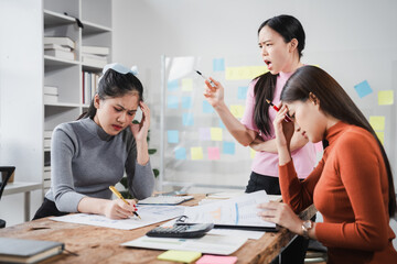 Asian people, frustrated businesswoman sits at desk, grappling with challenges of her startup, acknowledging failure, and seeking ways to learn and grow. team meeting. blamed