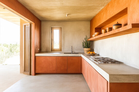 Modern minimalist terracotta kitchen with stone empty countertop, natural light and earth tones