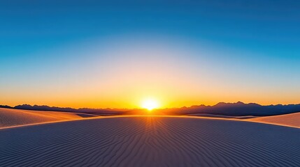 Sunrise over a vast desert landscape with rippling sand dunes and distant mountains