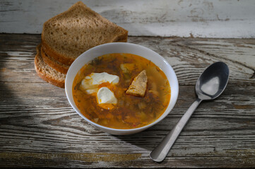 Comforting bowl of flavorful soup paired with fresh bread on a rustic wooden table