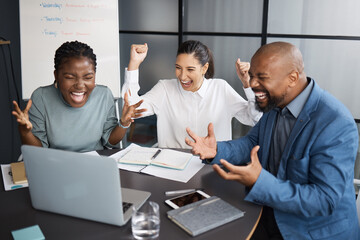 Architect, people and celebration in office with laptop, good news and email for building plan approval. Man, women and happy with cheers, success and winning bid for property development contract