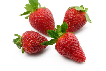 Freshly picked strawberries arranged artistically on a clean, white surface to showcase their vibrant color