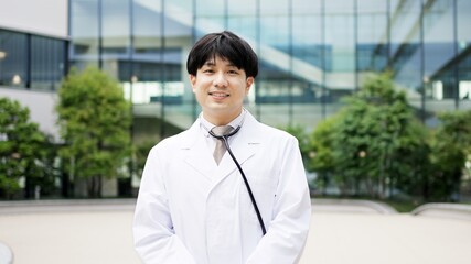 笑顔で立つアジア人の男性医師