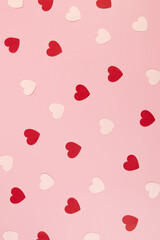 Top view of red and pink hearts on pink background. Valentine's day, pink hearts, red hearts, love wallpaper. Flat lay, copy space.