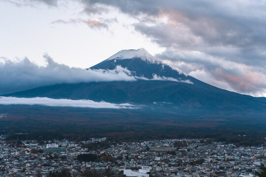 Snow-covered Fuji mountains above the village with a beautiful sunset landscape and cloudy sky