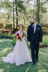 A blissful couple is joyfully strolling hand in hand throughout their enchanting outdoor wedding ceremony, which is set amidst strikingly beautiful nature and a breathtakingly picturesque landscape