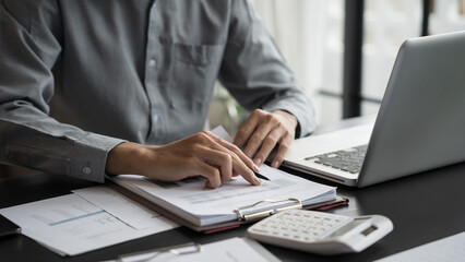 Asian business man holding paper document calculating tax insurance managing budget