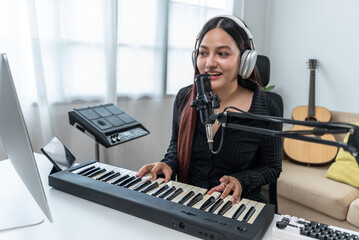 Professional Women Musician composing a song with acoustic guitar, piano keyboard and condenser...