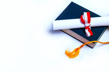 Diploma graduation hat and book isolated on white background