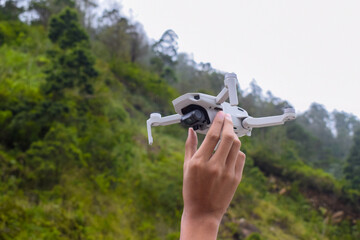 Quadcopter or drone in flight against the sky. A small drone takes off from a person's hand.