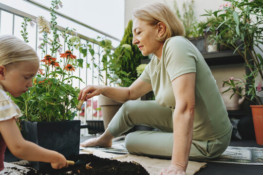Two people gardening together on a balcony promoting sustainability and teamwork