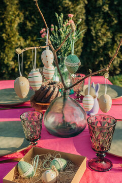 Dining table decorated with Easter eggs in back yard on sunny day