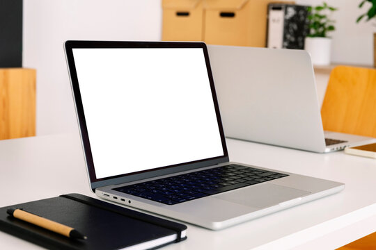 Laptop with blank screen near diary on desk