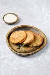 Delicious golden potato cakes served on a rustic wooden plate with dipping sauce