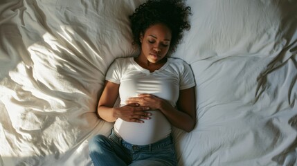 Woman in pain holding her lower abdomen while curled up