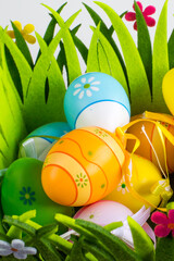 Vibrant holiday background. Still life with colorful Easter eggs in green grass box