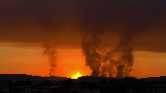 The camera captures a volcano erupting as the sun sets, blending warm lava flows with the soft evening sky