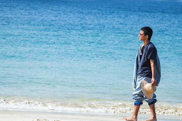 young man with hat enjoying himself on the beach shore