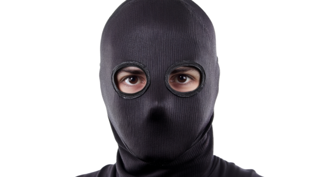 Thief wearing balaclava looking at you on transparent background