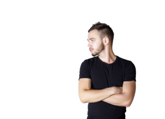 Young man int-shirt standing with arms crossed, looking to the side on a clean white background. Concept of casual fashion and attitude