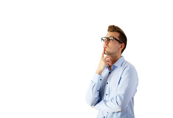 A thoughtful man wearing glasses and a light blue shirt, posing with a hand on his chin against a clean white background. Concept of contemplation