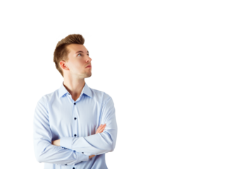 A young man in a striped blue shirt with arms crossed looks upward thoughtfully, isolated on a white background. Concept of thinking or confidence