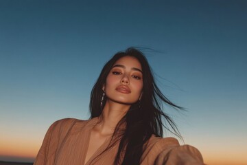 Fototapeta premium Serene woman posing against sunset sky