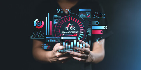 Person holding phone with risk management and data analytics graphics on dark background.