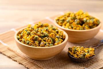 Dried Chrysanthemum flower tea in wooden bowl with spoon, Healthy herbal tea