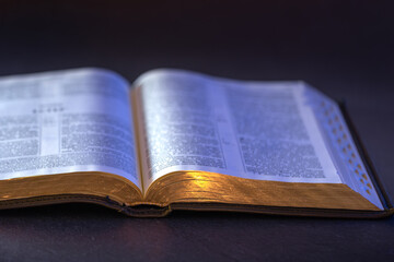 Obraz premium Open Holy Bible on the table. Religion concept. Bible on black background.