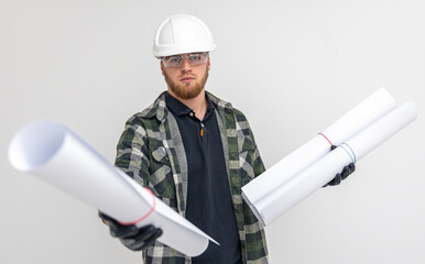 Fototapeta premium Male builder. Engineer in overalls and helmet holds blueprints and projects in his hands.