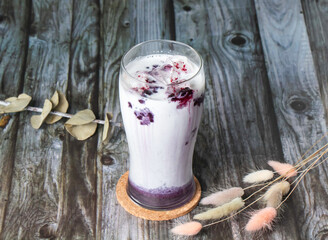 Iced Blueberry Latte layered with creamy milk and a vibrant blueberry swirl. The drink is served in...