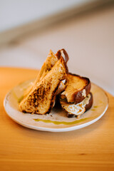 Melted chicken sandwich with golden toasted bread on a rustic plate