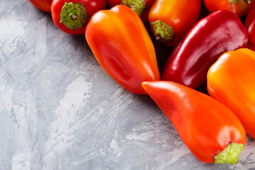 Ripe Colorful Bell Peppers Capsicum on Gray Concrete Background, Copy Space
