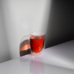 Closeup of a glass of red wine isolated on a table with hard black shadow.