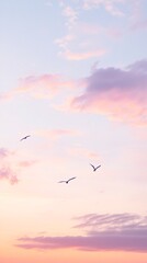 Fototapeta premium Graceful Birds in Flight Against a Dreamy Pink and Purple Sunset Sky, Minimalist Nature Photography Phone Wallpaper in 4K Ultra HD