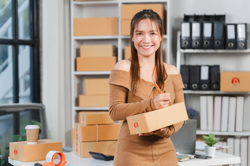 Smiling Entrepreneur: A young woman, brimming with confidence, smiles warmly as she holds a...