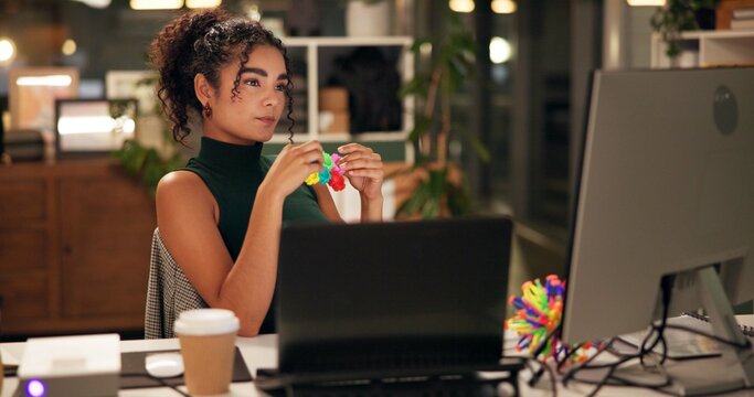 Business woman, computer and thinking with popit toy, creative agency and ideas for night brainstorming. Girl, brand consultant or multi screen laptop with project, proposal or office fidget stimming