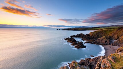 Fototapeta premium Coastal scenic nature idea. Stunning coastal view at sunset with smooth waves and rocky shoreline under vibrant sky.