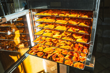 А food dehydrator machine for fruits. Slices of dried persimmons fruit in a home electric drying machine. An electric device for drying fruits without losing trace and vitamin elements. 