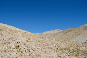 The southern part of the island of Krk in Croatia is defined by a barren, rocky terrain dotted with patches of resilient vegetation