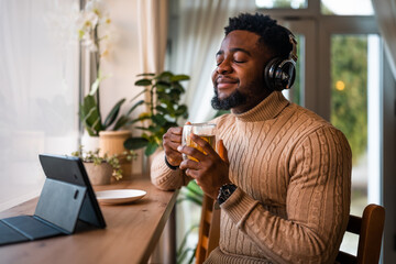 Freelancer using digital and having video call in bar. He is drinking tea.