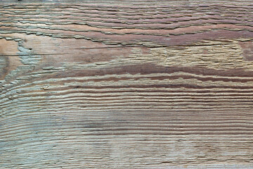 The old wooden plank is weathered, cracked, and rough.