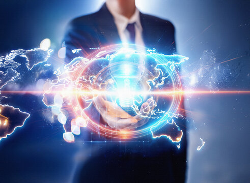 Abstract double exposure image. A businessman interacts with a glowing, futuristic world map, set against a dark sci-fi background.  The scene suggests global connection and technological advancement.